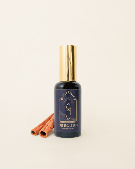 Parfum d'ambiance Mawja crépuscule sucré, flacon verre de face sur fond blanc avec bâton de cannelle